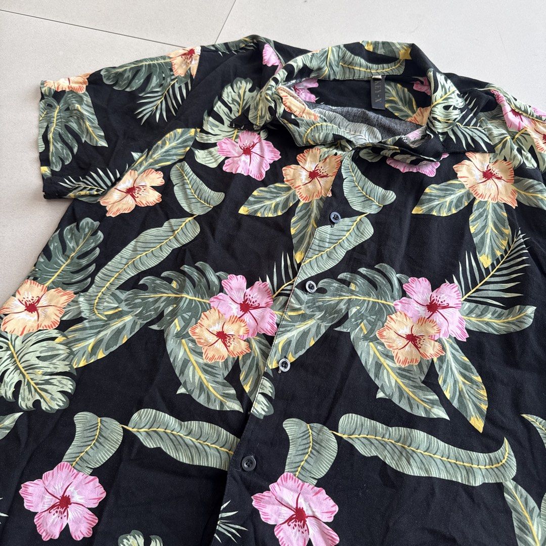 Floral Hibiscus Print Beach Shirt (Category: Shirts) located in Cebu City. Submitted by strawbeanz (Listing ID 1437464549, Image 2). Description: - Short sleeve shirt - Vibrant floral print - Button-down front - Classic collar - Colors: Pink, orange, white flowers with green leaves - Lightweight fabric - Ideal for casual, tropical wear.