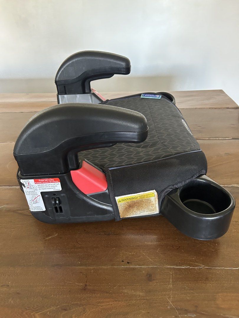 Graco Booster Seat with Cup Holders (Category: Car Seats) located in Taguig. Submitted by mdinvestbuildtrade (Listing ID 1437482302, Image 3). Description: - Graco booster seat - Black and gray patterned seat - Includes armrests and two cup holders - Features a red accent - Made with new material - Designed for child safety and comfort.