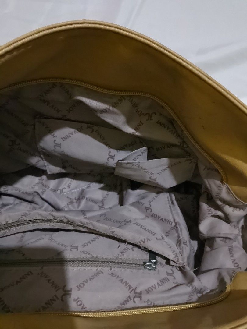 Jovanni Yellow Handbag (Category: Shoulder Bags) located in Manila. Submitted by ja_libn (Listing ID 1437568429, Image 3). Description: - Yellow leather handbag - Brown handle - Front zipper pocket - Spacious interior with Jovanni lining - Interior zipper pocket - Silver metal rings connecting handle -some issues are: missing zipper and a super minimal torn inside.