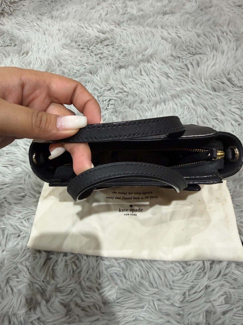 Kate Spade Cat Bag (Category: Luxury Bags & Wallets) located in Bustos. Submitted by keendolphin.add2a5 (Listing ID 1437492761, Image 3). Description: - Authentic Kate Spade handbag - Black exterior with a playful cat face design - Features: - Top handle - Detachable strap - Dust bag - Interior: - Zipper closure - Kate Spade label - Design details: Pink cat ears and gold-colored whiskers.