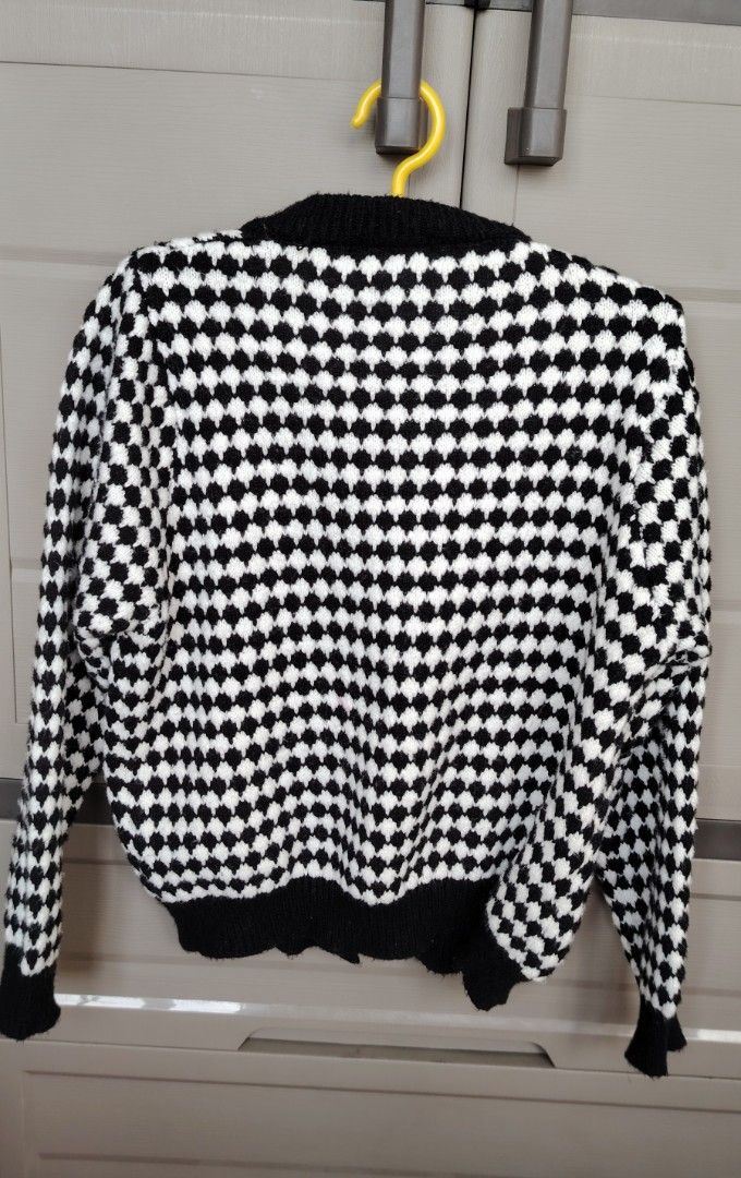 Knitted Cardigan Black and White (Category: Coats, Jackets and Outerwear) located in Mandaluyong City. Submitted by trisha_001 (Listing ID 1437567587, Image 3). Description: - Stylish black and white checkered cardigan - Classic pattern and round neckline - Button-down closure - Long sleeves with black cuffs - Black trim along the hem.