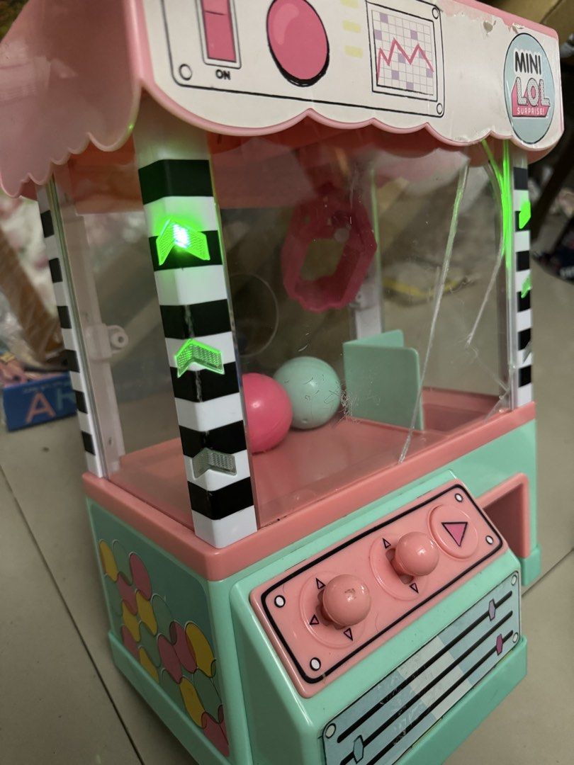 LOL Surprise! Mini Claw Machine Playset (Category: Toys & Games) located in Mandaluyong City. Submitted by elainelawenko (Listing ID 1437566790, Image 2). Description: - LOL Surprise! Mini Claw Machine - Tested and working - Acrylic is broken but can be glued - Includes free plushies and LOL Surprise! dolls - Requires 4 AA batteries - Colors: Pink and Mint Green.