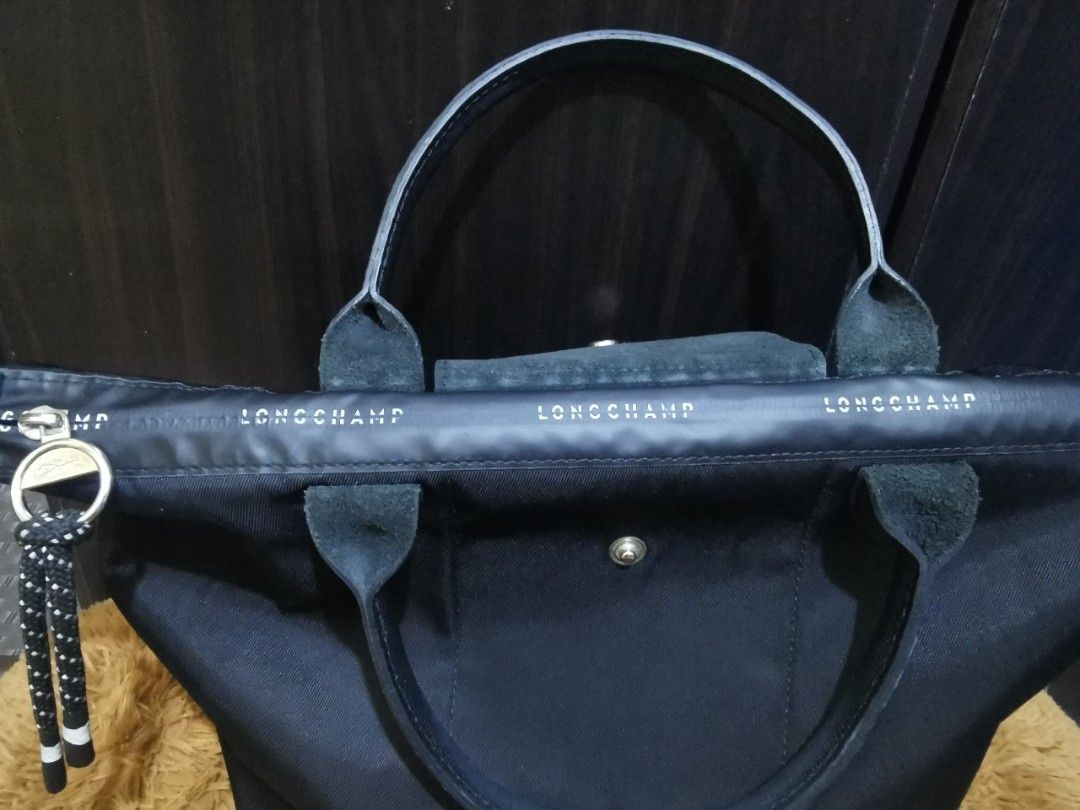 Longchamp Energy Handbag (Category: Luxury Bags & Wallets) located in Aringay. Submitted by ycels_purselove (Listing ID 1437484591, Image 2). Description: Brand: Longchamp Energy Handbag w/sling Condition: Like new Color: Black Size: small-medium Length = approximately 15in (upper body) / 9in (lower body) Width = 6in Height = 9in *** w/ YKK markings on zipper and stamped "longchamp modele depose" at the back of its leather cover.