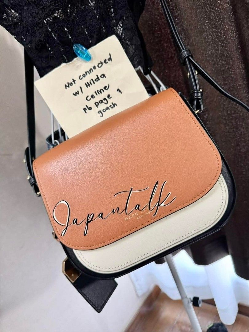 Marc Jacobs Saddle Bag (Category: Luxury Bags & Wallets) located in Bulacan. Submitted by vintage_purge (Listing ID 1437467680, Image 2). Description: - Marc Jacobs saddle bag - Tri-color design: tan flap, cream bottom, black sides - Black strap - Gold hardware - Includes Marc Jacobs New York tag.