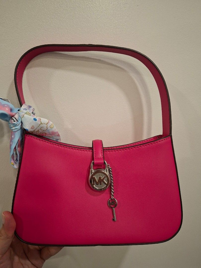 Michael Kors Pink Handbag (Category: Luxury Bags & Wallets) located in Mandaluyong City. Submitted by k__z__ (Listing ID 1437530401, Image 1). Description: - Authentic Michael Kors handbag - Eye-catching vibrant pink color - Stylish top handle - Elegant silver-tone clasp with Michael Kors logo, no hairline scratches, magnetoc clasp - Secure zipper closure - Interior lined with light-colored fabric RFS: bought for my daughter for 9k but she prefer