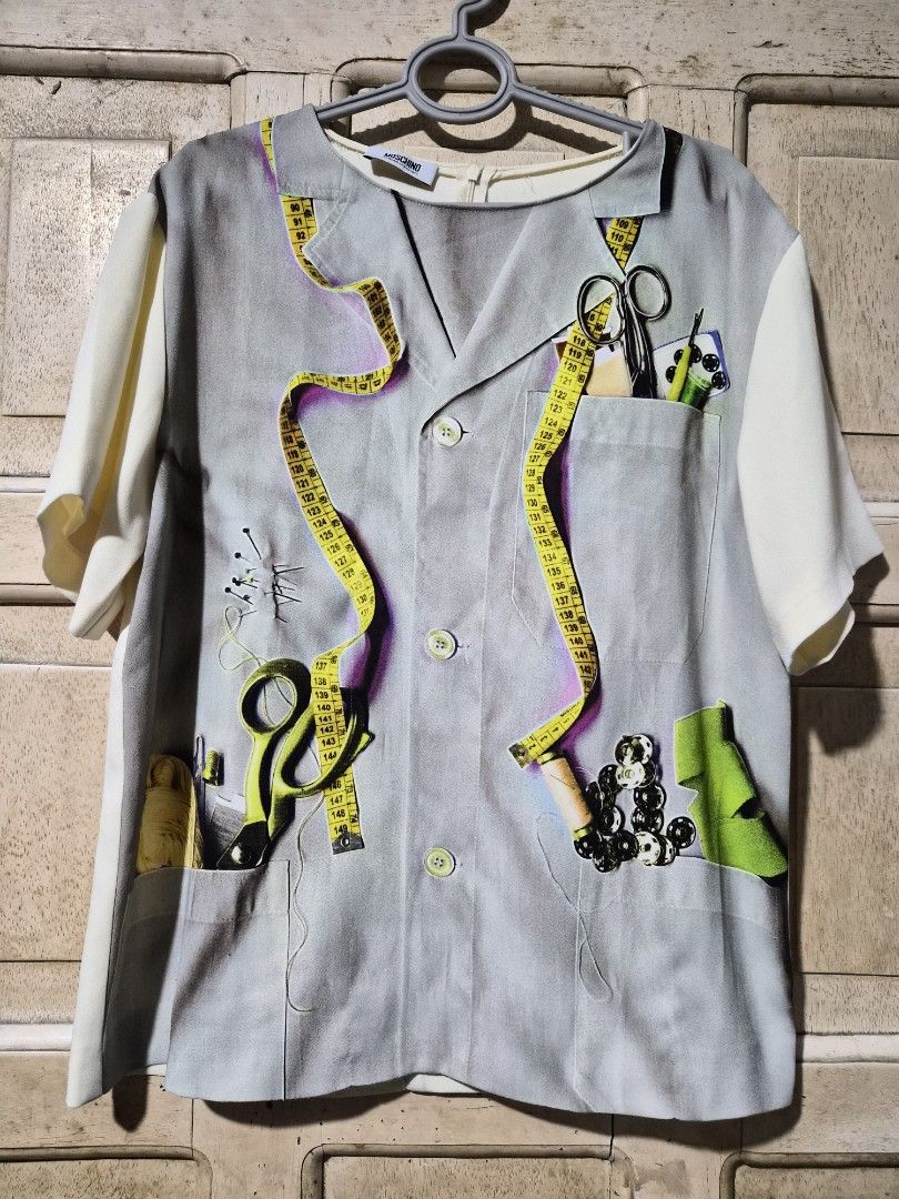 Moschino Cheap & Chic Multicolored Printed Crepe Blouse L (Category: Everything Else Others) located in Mandaue City. Submitted by chuchi152615 (Listing ID 1437406907, Image 1). Description: - Moschino Cheap & Chic blouse - Unique print featuring sewing tools - Size: L - Collared neckline - Short sleeves - Button-down front - Plain white back with zipper closure - White sleeves.