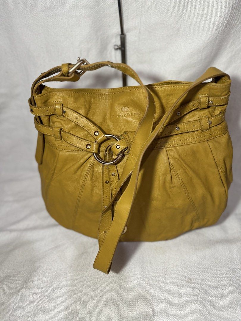 Hiroshima Mustard Yellow Leather Shoulder Bag (Category: Luxury Bags & Wallets) located in Cavite. Submitted by bags_unltd143 (Listing ID 1437447080, Image 1). Description: Mustard yellow leather shoulder bag by Hiroshima. Features a long adjustable strap and a shorter handle. The bag has a large main compartment with a floral patterned lining. It has a decorative ring detail on the front and multiple straps with rivets. The bag has a rounded sha
