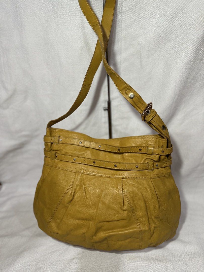 Hiroshima Mustard Yellow Leather Shoulder Bag (Category: Luxury Bags & Wallets) located in Cavite. Submitted by bags_unltd143 (Listing ID 1437447080, Image 2). Description: Mustard yellow leather shoulder bag by Hiroshima. Features a long adjustable strap and a shorter handle. The bag has a large main compartment with a floral patterned lining. It has a decorative ring detail on the front and multiple straps with rivets. The bag has a rounded sha