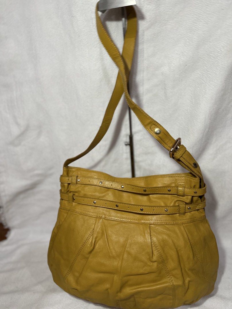 Hiroshima Mustard Yellow Leather Shoulder Bag (Category: Luxury Bags & Wallets) located in Cavite. Submitted by bags_unltd143 (Listing ID 1437447080, Image 3). Description: Mustard yellow leather shoulder bag by Hiroshima. Features a long adjustable strap and a shorter handle. The bag has a large main compartment with a floral patterned lining. It has a decorative ring detail on the front and multiple straps with rivets. The bag has a rounded sha