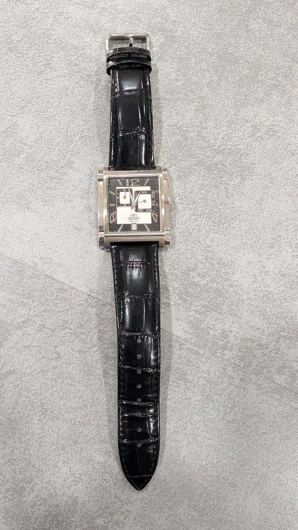 Orient Rectangular Dial Watch (Category: Watches) located in Simpang. Submitted by mohidza (Listing ID 1437474984, Image 3). Description: - Orient rectangular watch -Automatic - Black dial - Day and date display - Silver-tone case - Black crocodile-pattern leather strap - Buckle clasp - Orient logo on the back.