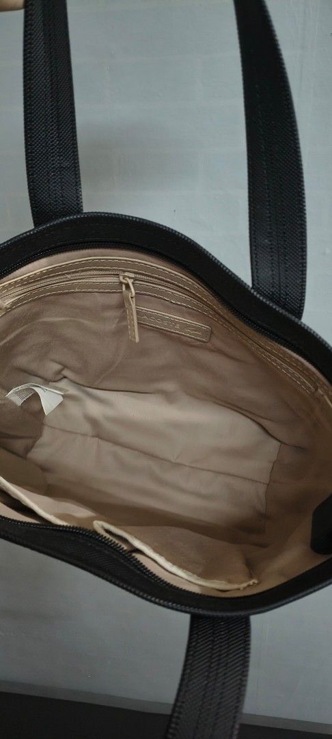 Original lacoste Black Tote Bag with Interior Pockets (Category: Shoulder Bags) located in Pasig City. Submitted by lfboutique (Listing ID 1437492323, Image 3). Description: - original lacoste Black tote bag - Two handles - Light-colored lining - Zippered pocket inside - Durable material - Small logo on the front in very good condition pasig loc no cod.