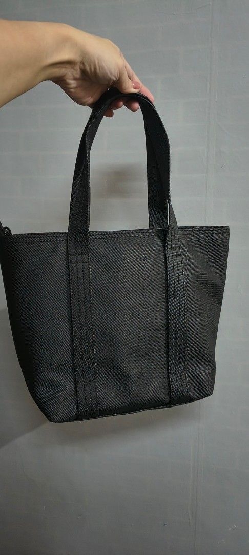 Original lacoste Black Tote Bag with Interior Pockets (Category: Shoulder Bags) located in Pasig City. Submitted by lfboutique (Listing ID 1437492323, Image 2). Description: - original lacoste Black tote bag - Two handles - Light-colored lining - Zippered pocket inside - Durable material - Small logo on the front in very good condition pasig loc no cod.