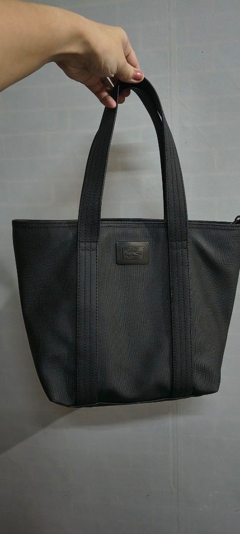 Original lacoste Black Tote Bag with Interior Pockets (Category: Shoulder Bags) located in Pasig City. Submitted by lfboutique (Listing ID 1437492323, Image 1). Description: - original lacoste Black tote bag - Two handles - Light-colored lining - Zippered pocket inside - Durable material - Small logo on the front in very good condition pasig loc no cod.