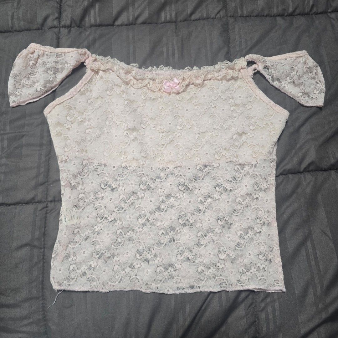 Pink Floral Lace Top (Category: Sleeveless) located in Adams. Submitted by declutter.seasonnn (Listing ID 1437411777, Image 1). Description: - Light pink lace top - Asymmetrical design - Single shoulder strap - Small bow detail - Ruffled trim - Lightweight and semi-sheer fabric - Perfect for layering.