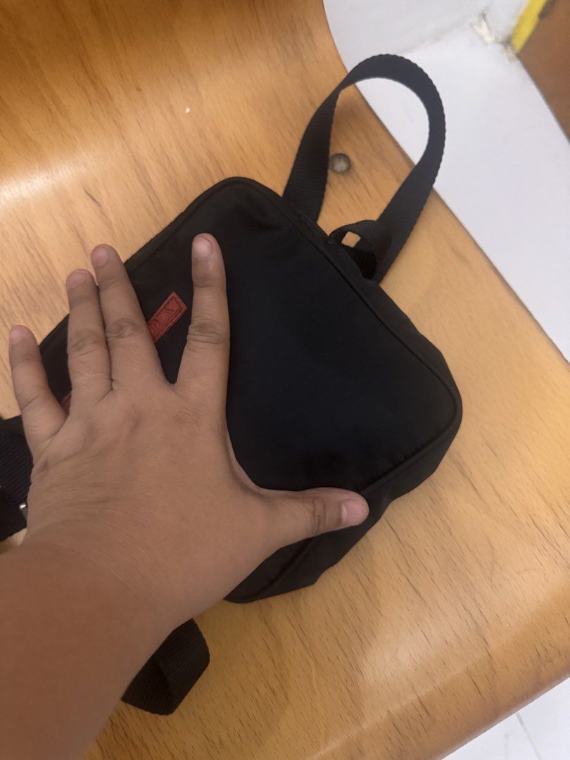 Prada Black Messenger Bag (Category: Luxury Bags & Wallets) located in Koronadal. Submitted by milagraciaukayukay123_. (Listing ID 1437556318, Image 2). Description: - Authentic Prada messenger bag - Classic black nylon material - Iconic red Prada logo - Secure zip closure - Adjustable strap for comfortable wear - Interior tag with serial number 7 - Ideal size for daily essentials.