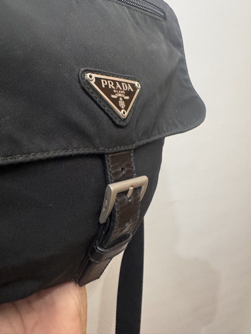 Prada Black Nylon Messenger Bag (Category: Luxury Bags & Wallets) located in Koronadal. Submitted by milagraciaukayukay123_. (Listing ID 1437556537, Image 3). Description: - Authentic Prada messenger bag - Black nylon material - Flap closure with buckle - Front zip pocket - Adjustable shoulder strap - Prada logo detail - Interior with patterned lining - Zip closure inside - Features "LAMPO" zippers.
