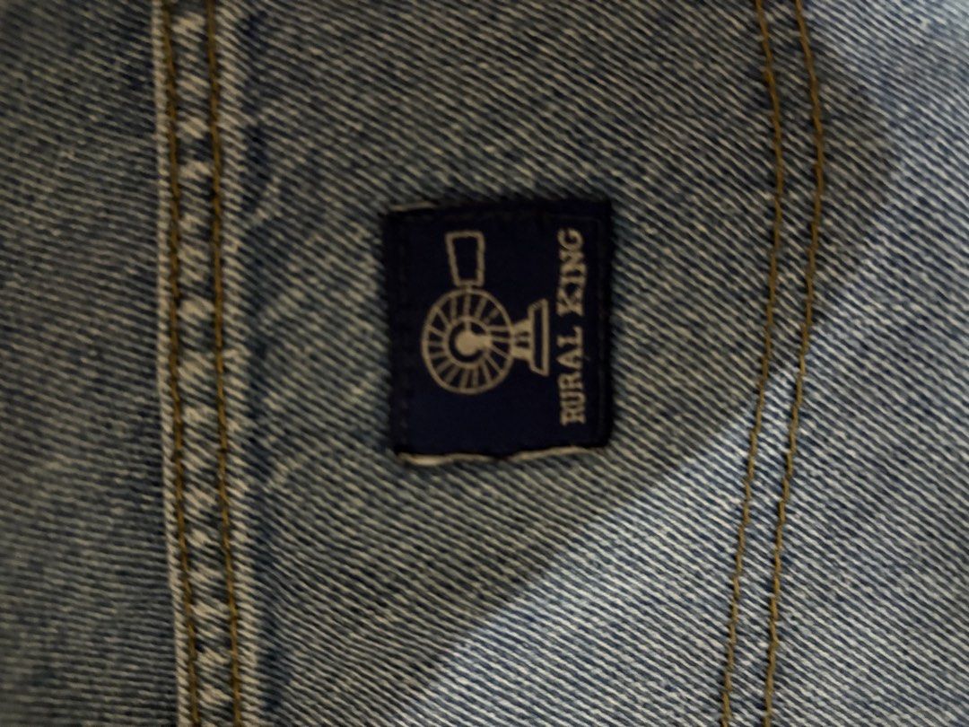 Rural King Carpenter Jeans 34x32 (Category: Jeans) located in Quezon City. Submitted by unusuals_thrift (Listing ID 1437566114, Image 2). Description: Rural King carpenter jeans in a light blue wash. Features a classic five-pocket design with additional carpenter pockets. The jeans are size 34x32 and made of 100% cotton. The Rural King logo is visible on the back pocket. These jeans offer a comfortable fit and a durable construction, perfect for 