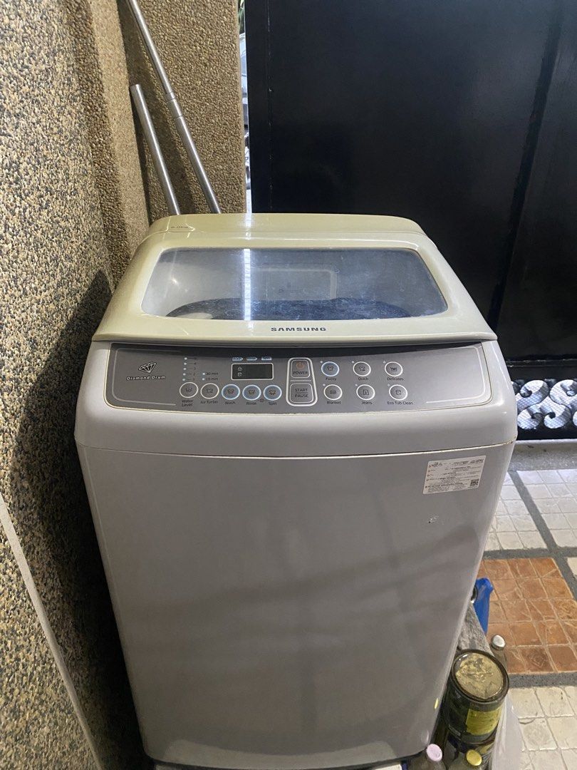 Samsung Top Load Washing Machine (Category: Washing Machines and Dryers) located in Binan City. Submitted by nicadgzmn (Listing ID 1437455431, Image 1). Description: - Samsung top load washing machine - Diamond Drum technology - Wash cycles: Fuzzy, Quick, Delicates - Built-in detergent dispenser - Light grey color - Water inlet connections at the back.