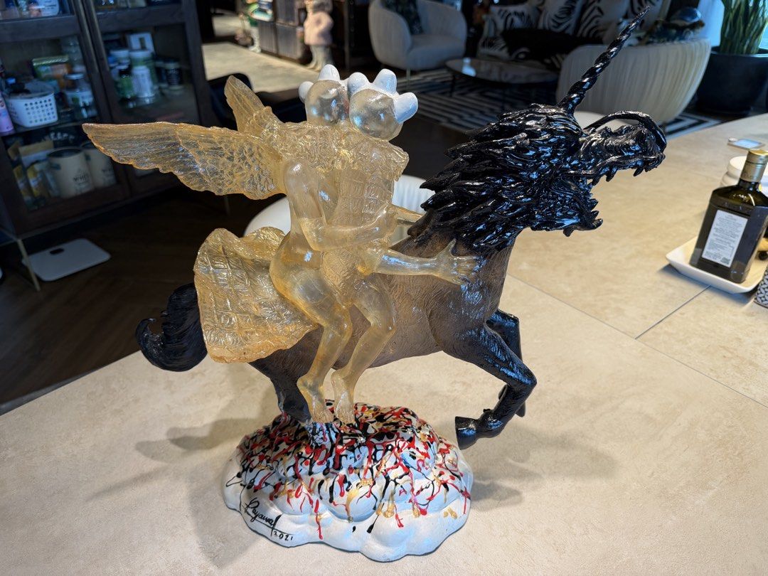 Sculpture 2021 (Category: Other Home Decor) located in Quezon City. Submitted by declutterqueenhigh5 (Listing ID 1437482131, Image 1). Description: - sculpture, dated 2021 - Features a unicorn with a black mane and tail - Two winged figures riding the unicorn - Cloud-shaped base with colorful paint drips - Intricate details and striking design.