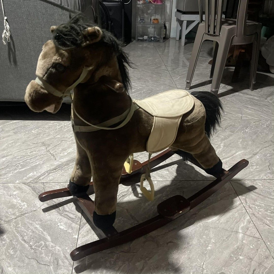 Vintage Rocking Horse (Category: Kids Toys) located in Manila. Submitted by trooopers (Listing ID 1437500796, Image 2). Description: - Plush brown rocking horse - Features black mane and tail - Includes saddle and stirrups - Mounted on wooden rockers - Ideal for young children.