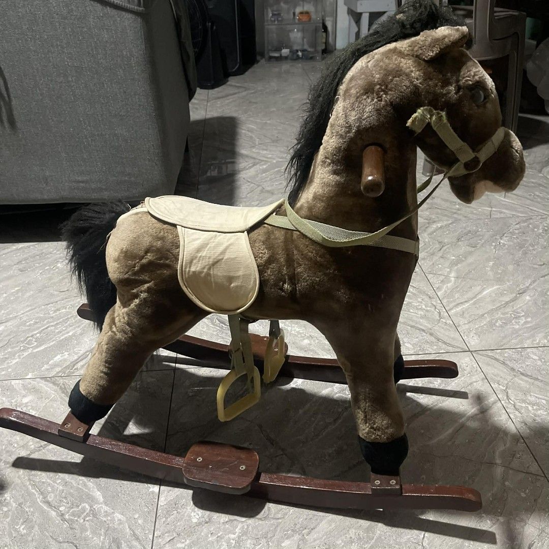 Vintage Rocking Horse (Category: Kids Toys) located in Manila. Submitted by trooopers (Listing ID 1437500796, Image 1). Description: - Plush brown rocking horse - Features black mane and tail - Includes saddle and stirrups - Mounted on wooden rockers - Ideal for young children.