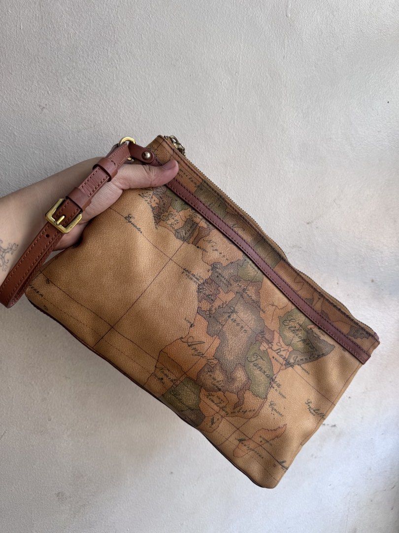 Alviero Martini Clutch bag (Category: Luxury Bags & Wallets) located in Manila. Submitted by thriftyhaven2023 (Listing ID 1437605958, Image 1). Description: - alviero clutch - Unique map print design - Includes wrist strap - Gold-tone zipper - Branded leather tag inside - Minimal signs of wear - Stylish for everyday use 9/10 condition No flaws Kasya long wallet.