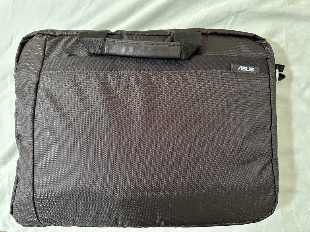 ASUS Laptop Bag (Category: Laptop Bags & Sleeves) located in Las Pinas. Submitted by tomarigato (Listing ID 1437654977, Image 1). Description: - Black ASUS laptop bag - Features a handle for easy carrying - Textured, durable material - Includes a front pocket - Zipper closure for security - Designed to protect your laptop.