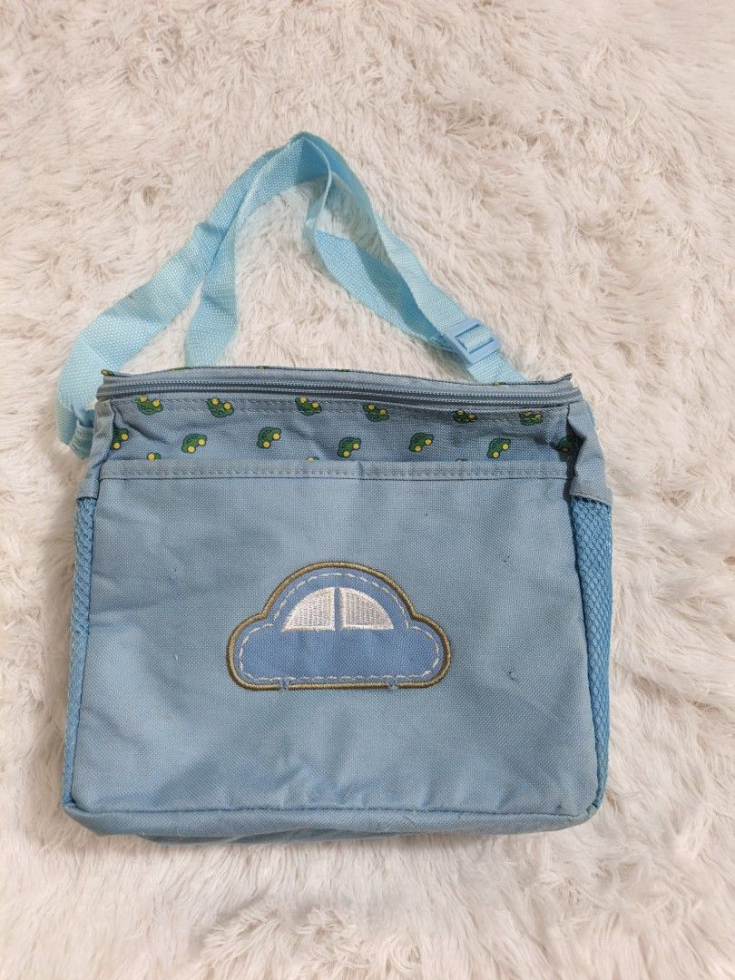 Baby go bag (Category: Other Babies Going Out Needs) located in Marikina City. Submitted by andreah_16 (Listing ID 1437597578, Image 2). Description: - Blue lunch bag with car design - Features small car patterns on top - Insulated interior - Includes a shoulder strap - Has a mesh side pocket - Secure zipper closure - Perfect size for lunch and snacks.