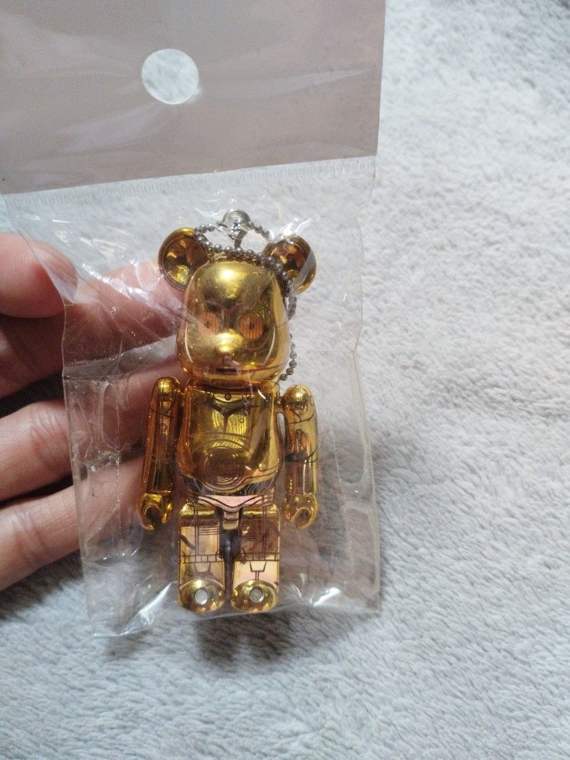 Bearbrick C-3PO Keychain (Category: Character Goods) located in Davao. Submitted by mengsmixitems (Listing ID 1437640251, Image 1). Description: - Gold C-3PO Bearbrick keychain - Includes chain for easy attachment - Features detailed C-3PO design - Still in original packaging - Great for Star Wars collectors.
