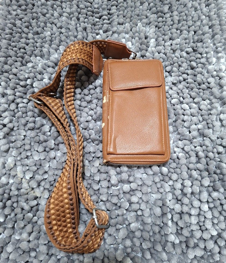Brown Crossbody Bag with Woven Strap (Category: Cross-body Bags) located in Batangas. Submitted by sell_ph (Listing ID 1437699579, Image 1). Description: - Brown crossbody bag - Woven strap - Zippered main compartment - Multiple card slots - Small inner pocket - Adjustable strap with metal buckle - Shows wear on edges - Practical for everyday use.