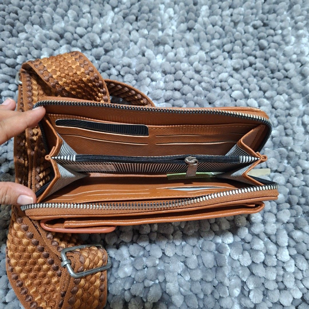 Brown Crossbody Bag with Woven Strap (Category: Cross-body Bags) located in Batangas. Submitted by sell_ph (Listing ID 1437699579, Image 3). Description: - Brown crossbody bag - Woven strap - Zippered main compartment - Multiple card slots - Small inner pocket - Adjustable strap with metal buckle - Shows wear on edges - Practical for everyday use.