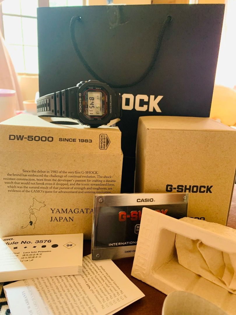 Casio G-Shock DW-5000R (Category: Men's Watches) located in Balingasag. Submitted by earthlythings (Listing ID 1437585271, Image 3). Description: - Authentic Casio G-Shock DW-5000 - Digital display: time, date, day - Includes original box, papers, and packaging - Comes with G-Shock shopping bag - Black strap and case with red accents.