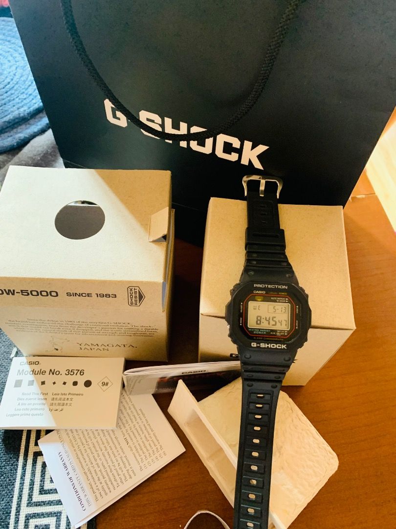 Casio G-Shock DW-5000R (Category: Men's Watches) located in Balingasag. Submitted by earthlythings (Listing ID 1437585271, Image 2). Description: - Authentic Casio G-Shock DW-5000 - Digital display: time, date, day - Includes original box, papers, and packaging - Comes with G-Shock shopping bag - Black strap and case with red accents.