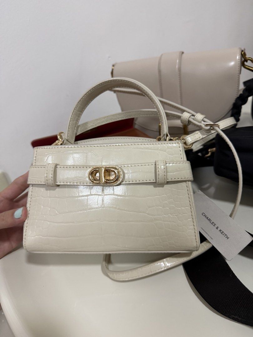 Charles & Keith Aubrielle Ivory Croc-Embossed Mini Bag (Category: Luxury Bags & Wallets) located in Muntinlupa City. Submitted by genhart (Listing ID 1437724842, Image 1). Description: - Charles & Keith mini bag - Color: Ivory - Size: S - Features: - Croc-embossed pattern - Top handle - Detachable shoulder strap - Gold-tone clasp and hardware - Lined interior - Brand new with original tag -Wore twice Korea and Photoshoot -decluttering.