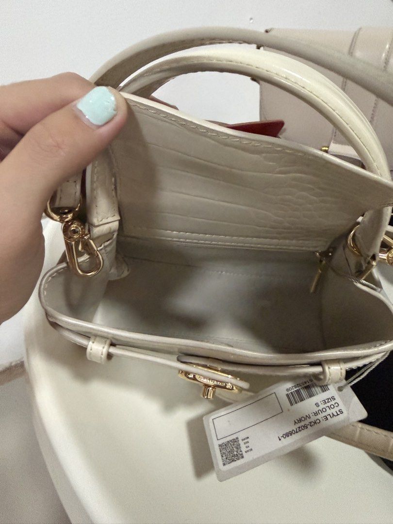 Charles & Keith Aubrielle Ivory Croc-Embossed Mini Bag (Category: Luxury Bags & Wallets) located in Muntinlupa City. Submitted by genhart (Listing ID 1437724842, Image 3). Description: - Charles & Keith mini bag - Color: Ivory - Size: S - Features: - Croc-embossed pattern - Top handle - Detachable shoulder strap - Gold-tone clasp and hardware - Lined interior - Brand new with original tag -Wore twice Korea and Photoshoot -decluttering.