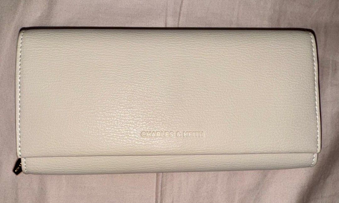 Charles and Keith Muriel Front Flap Long Wallet - Oat (Category: Luxury Bags & Wallets) located in Manila. Submitted by prettyfindsss (Listing ID 1437752800, Image 2). Description: QUICK SPECS: Brand: Charles & Keith Model: Muriel Front Flap Long Wallet - Oat Condition: 10/10 — Excellent, like-new condition. Material: Tumble PU (Faux Leather) with a clean, unembellished exterior. Features: Maximized Organization: Includes 18 card slots and 2 inne