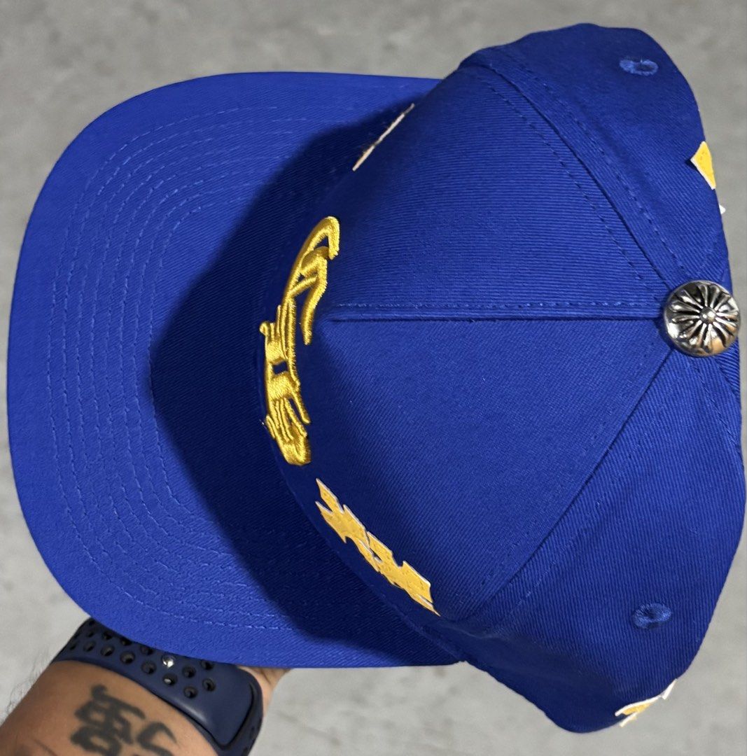 Chrome Hearts CH Blue Gold Cap High Quality Replica (Category: Caps & Hats) located in Hermosa. Submitted by breestyle (Listing ID 1437596184, Image 2). Description: • Royal blue colorway • Clean yellow embroidery • Chrome Hearts style cross patches • Silver top button detail • Adjustable snapback fit • Structured shape and thick material • Actual photos posted Very eye-catching color combination and looks premium in person..