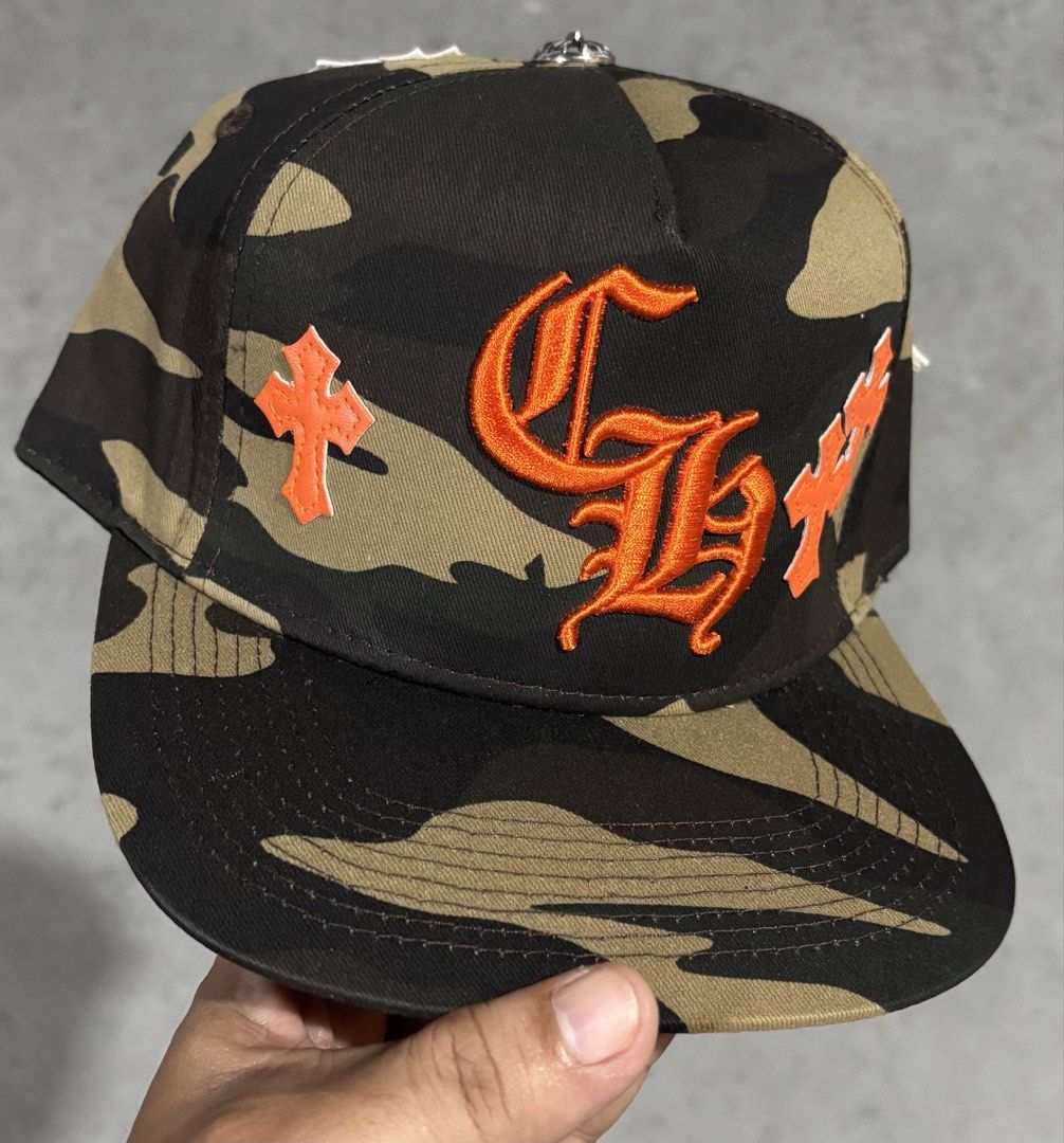 Chrome Hearts Inspired Camo Snapback Cap Premium Quality Replica (Category: Caps & Hats) located in Hermosa. Submitted by breestyle (Listing ID 1437595726, Image 1). Description: • High quality embroidery • Orange cross patch details • Adjustable snapback • Thick fabric and clean stitching • Streetwear / hype style • Very good condition Looks premium in person and not like low-quality market replicas. Actual photos posted..