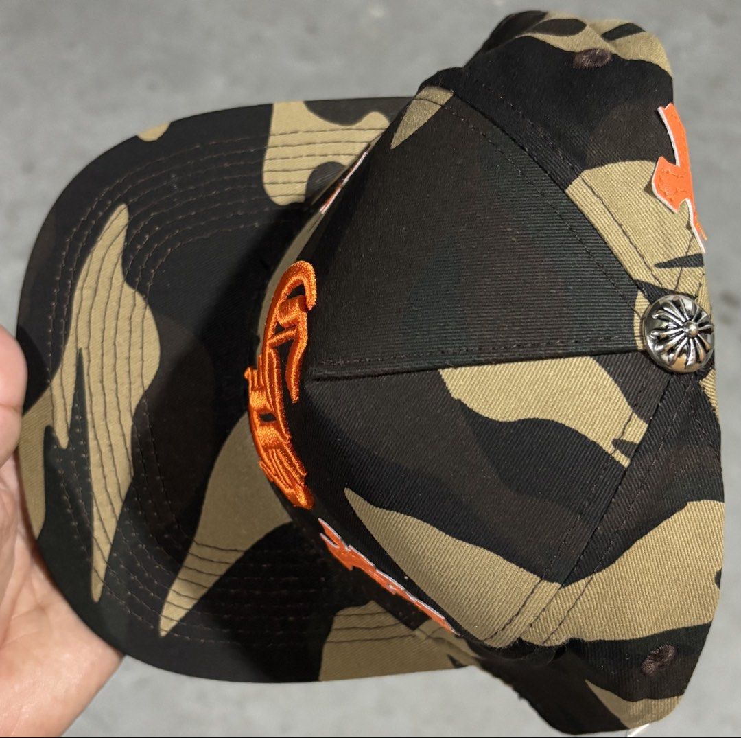 Chrome Hearts Inspired Camo Snapback Cap Premium Quality Replica (Category: Caps & Hats) located in Hermosa. Submitted by breestyle (Listing ID 1437595726, Image 3). Description: • High quality embroidery • Orange cross patch details • Adjustable snapback • Thick fabric and clean stitching • Streetwear / hype style • Very good condition Looks premium in person and not like low-quality market replicas. Actual photos posted..