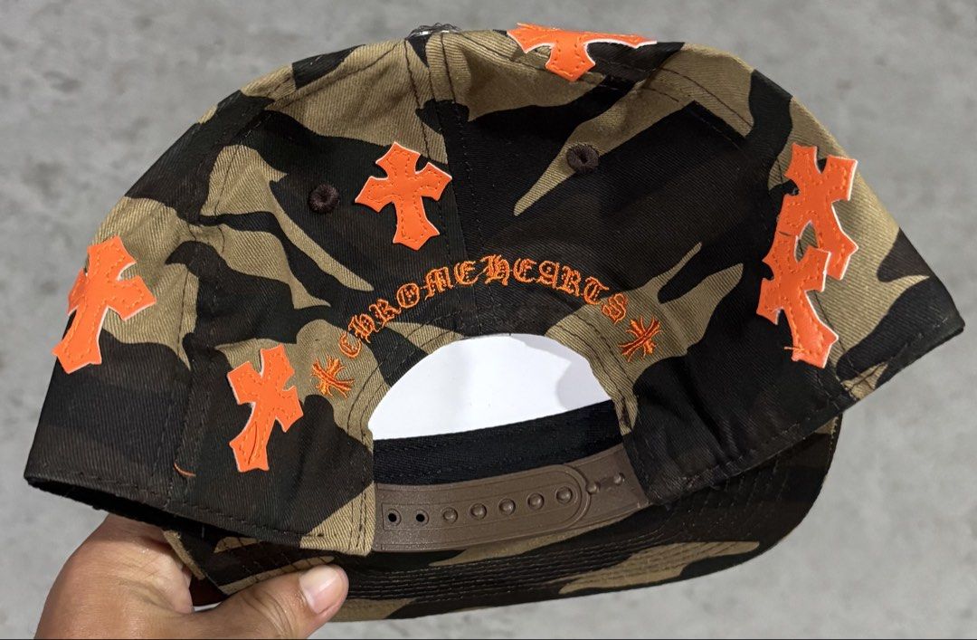 Chrome Hearts Inspired Camo Snapback Cap Premium Quality Replica (Category: Caps & Hats) located in Hermosa. Submitted by breestyle (Listing ID 1437595726, Image 2). Description: • High quality embroidery • Orange cross patch details • Adjustable snapback • Thick fabric and clean stitching • Streetwear / hype style • Very good condition Looks premium in person and not like low-quality market replicas. Actual photos posted..