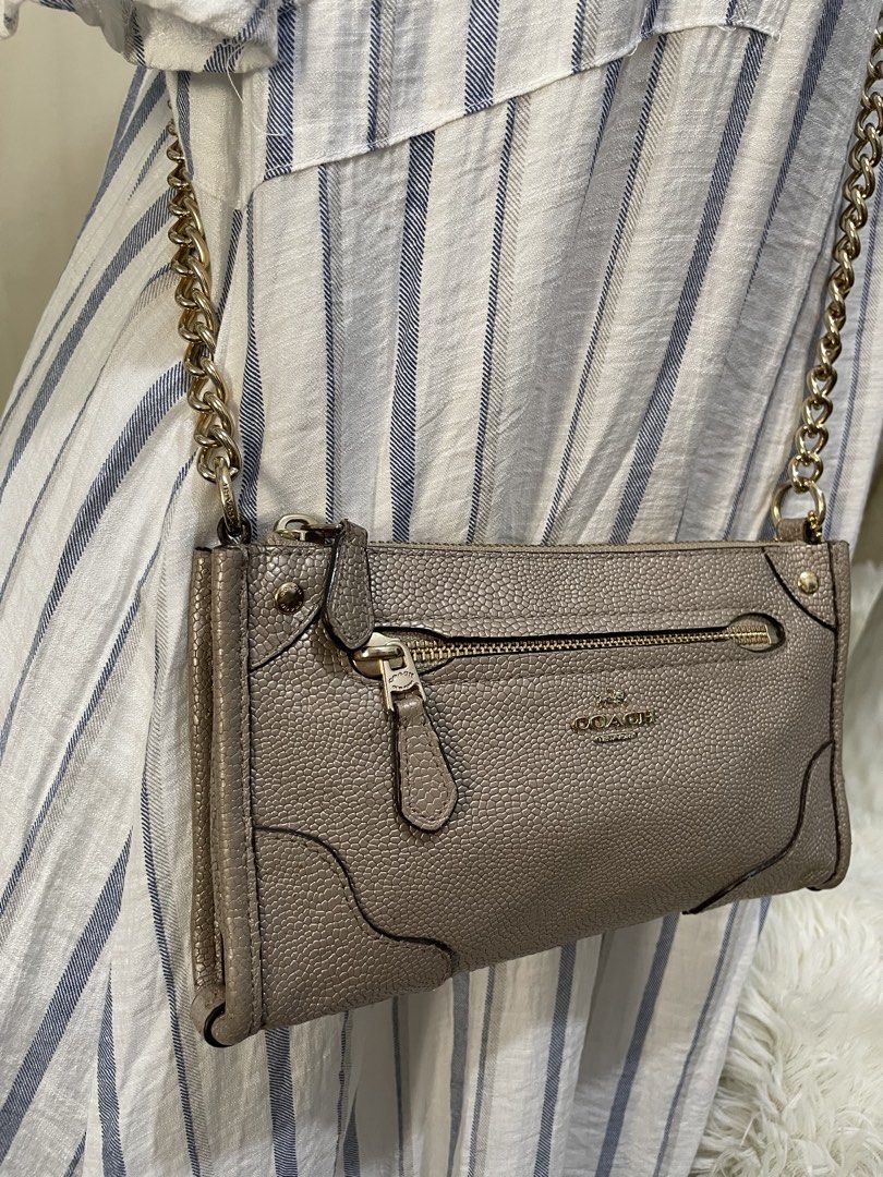 MARKED DOWN! Coach Crossbody Bag with Chain Strap (Category: Luxury Bags & Wallets) located in Cabanatuan. Submitted by moraiahraven (Listing ID 1437629527, Image 2). Description: Coach crossbody bag features a chain strap and a zip closure. It has a pebbled texture and a small Coach logo on the front. The interior includes card slots and a main compartment. The bag is a neutral color, suitable for various outfits..