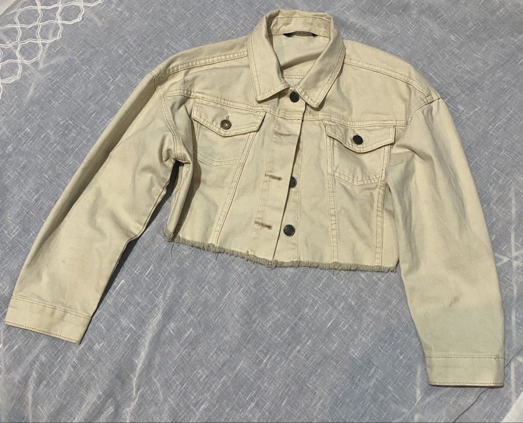 Cropped Denim Jacket (Category: Coats, Jackets and Outerwear) located in Santa Rosa. Submitted by jas_preloved21 (Listing ID 1437686986, Image 3). Description: - Cream-colored cropped denim jacket - Classic collar and button-down closure - Two chest pockets - Long sleeves with buttoned cuffs - Raw hem - Slightly distressed look - Perfect for layering.