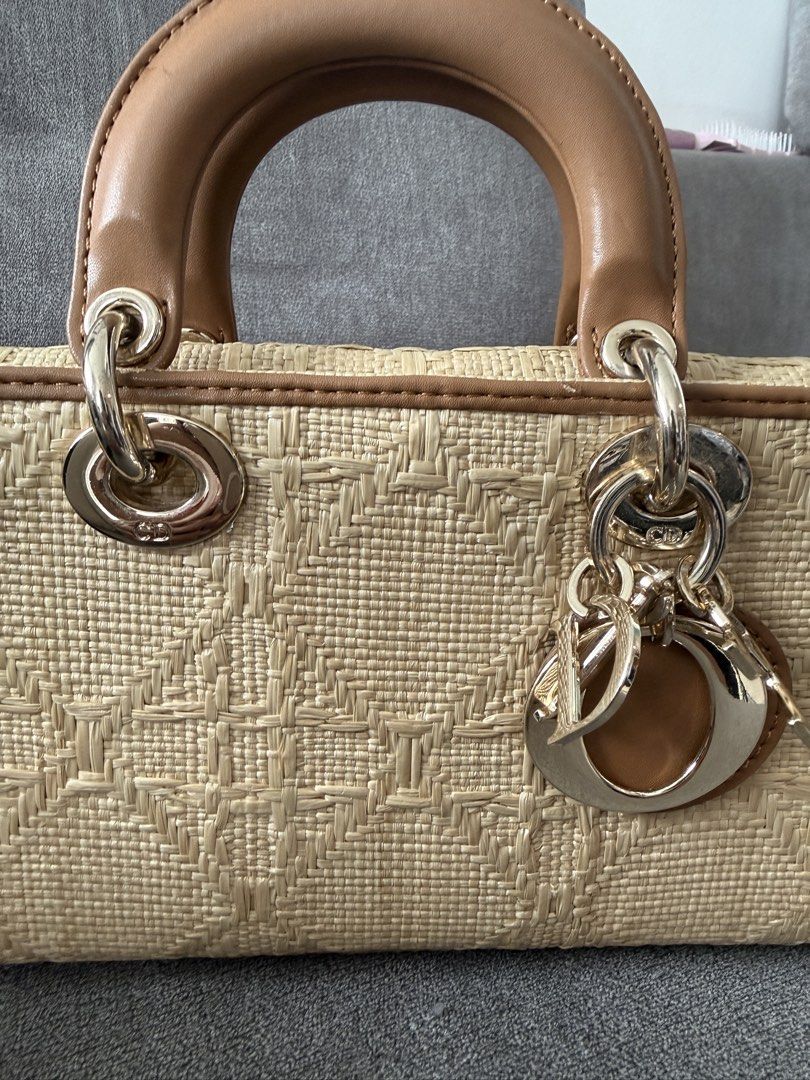 Dior Lady D-Joy Raffia Bag (Category: Luxury Bags & Wallets) located in Pasig City. Submitted by andria_james (Listing ID 1437622716, Image 2). Description: - Budget friendly. Please manage expectation. Lady D-Joy bag crafted from raffia. - Structured silhouette with a top handle. - Detachable chain included. - Interior: main compartment and slip pocket. - Adorned with signature Dior charms. - Neutral color palette with brown leather accents..