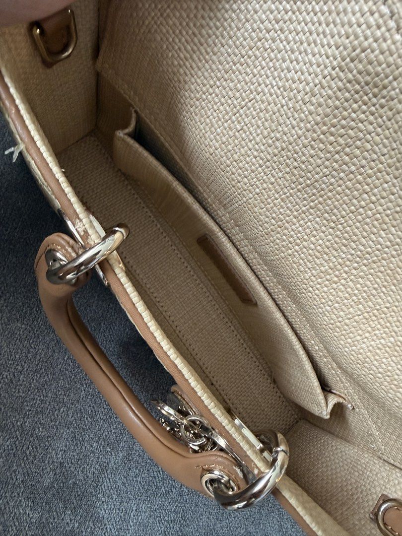 Dior Lady D-Joy Raffia Bag (Category: Luxury Bags & Wallets) located in Pasig City. Submitted by andria_james (Listing ID 1437622716, Image 3). Description: - Budget friendly. Please manage expectation. Lady D-Joy bag crafted from raffia. - Structured silhouette with a top handle. - Detachable chain included. - Interior: main compartment and slip pocket. - Adorned with signature Dior charms. - Neutral color palette with brown leather accents..