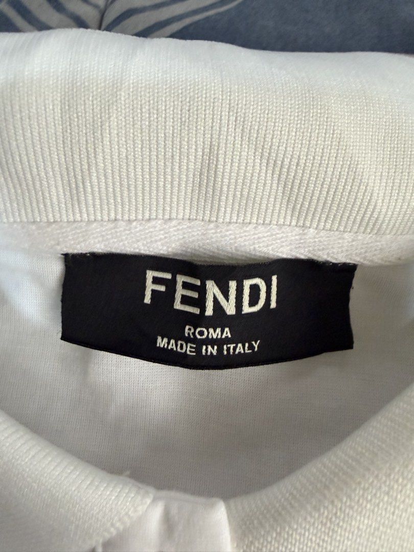 Fendi Polo Shirt (Category: Tshirts & Polo Shirts ) located in Pasig City. Submitted by mswise (Listing ID 1437665910, Image 3). Description: - Authentic Fendi polo shirt - Features embroidered Fendi logo - Classic polo collar with brown accents - Made in Italy - White shirt with brown collar and sleeve accents - Care label indicates made in China Chest size - 20inches laid flat.