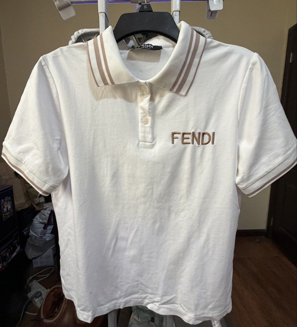 Fendi Polo Shirt (Category: Tshirts & Polo Shirts ) located in Pasig City. Submitted by mswise (Listing ID 1437665910, Image 1). Description: - Authentic Fendi polo shirt - Features embroidered Fendi logo - Classic polo collar with brown accents - Made in Italy - White shirt with brown collar and sleeve accents - Care label indicates made in China Chest size - 20inches laid flat.