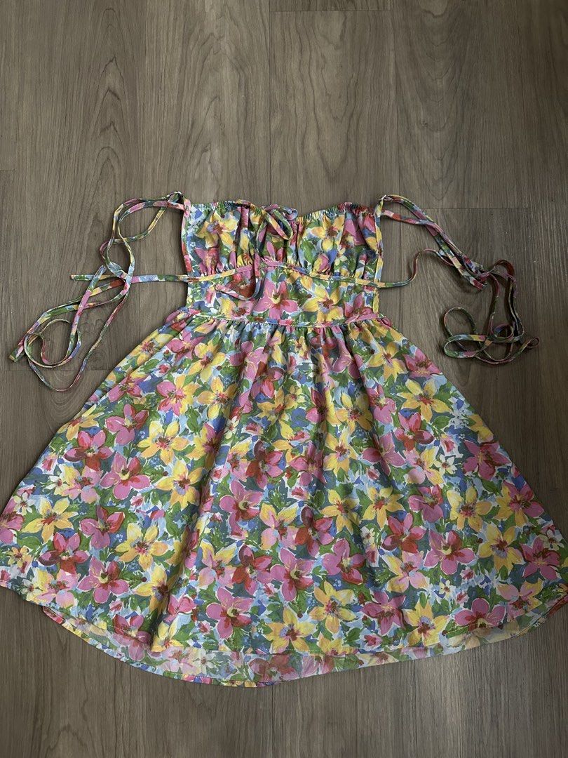 Floral Summer Dress (Category: Dresses) located in Quezon City. Submitted by prelovedbyasg (Listing ID 1437581440, Image 1). Description: Summer dress features a vibrant floral print. It has a strapless design with tie straps for an adjustable fit. The dress has a fitted bodice and a flared skirt. It is perfect for warm weather and casual outings. The dress is made of a lightweight fabric..