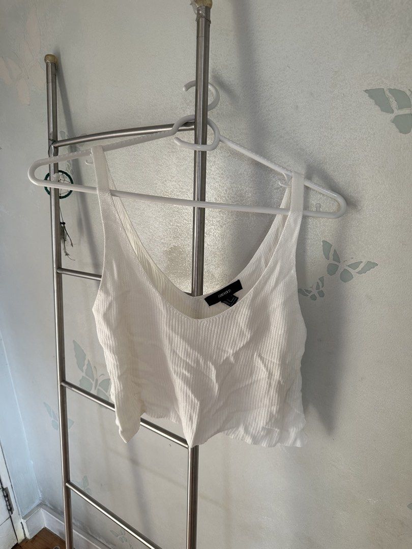 Forever 21 White Ribbed Tank Top (Category: Sleeveless) located in Quezon City. Submitted by cam.declutters (Listing ID 1437668694, Image 1). Description: White ribbed tank top from Forever 21. Features a scoop neck and a cropped length. The tag indicates a size S. Made in China. Perfect for layering or wearing on its own. A versatile piece for your wardrobe..