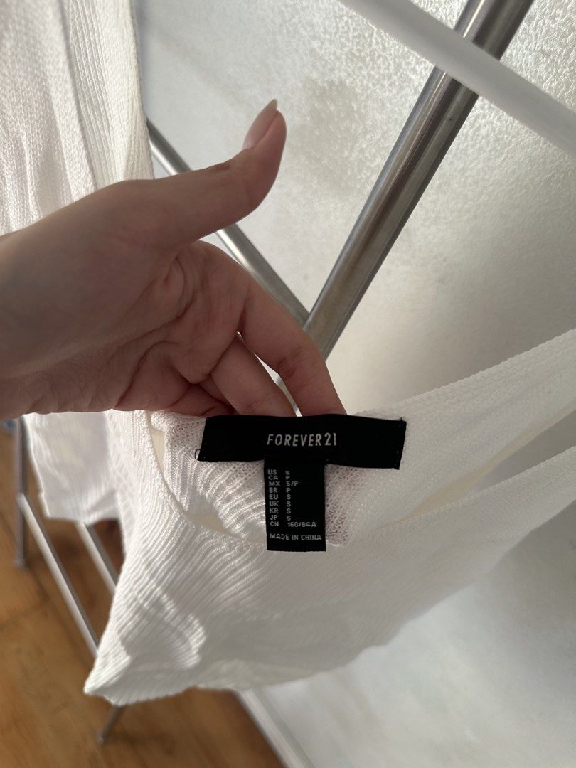Forever 21 White Ribbed Tank Top (Category: Sleeveless) located in Quezon City. Submitted by cam.declutters (Listing ID 1437668694, Image 3). Description: White ribbed tank top from Forever 21. Features a scoop neck and a cropped length. The tag indicates a size S. Made in China. Perfect for layering or wearing on its own. A versatile piece for your wardrobe..