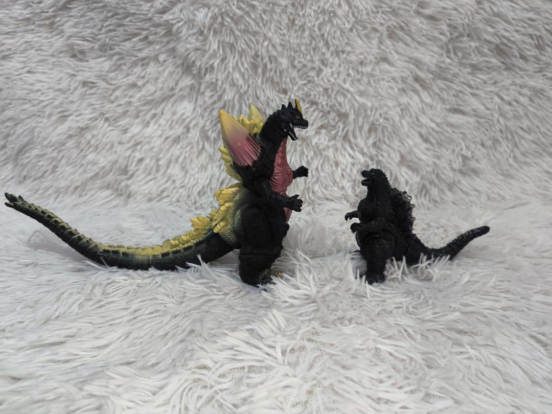 Godzilla Toy Figures (Category: Figurines & Statues) located in Pasig City. Submitted by 1stop-shop (Listing ID 1437651901, Image 2). Description: - Godzilla figures available! - ₱300.00 each - Large Godzilla: - Features yellow and red dorsal fin. - Size reference: Rebisco crackers box. - Small Godzilla: - Black figure. - Size reference: Battery..